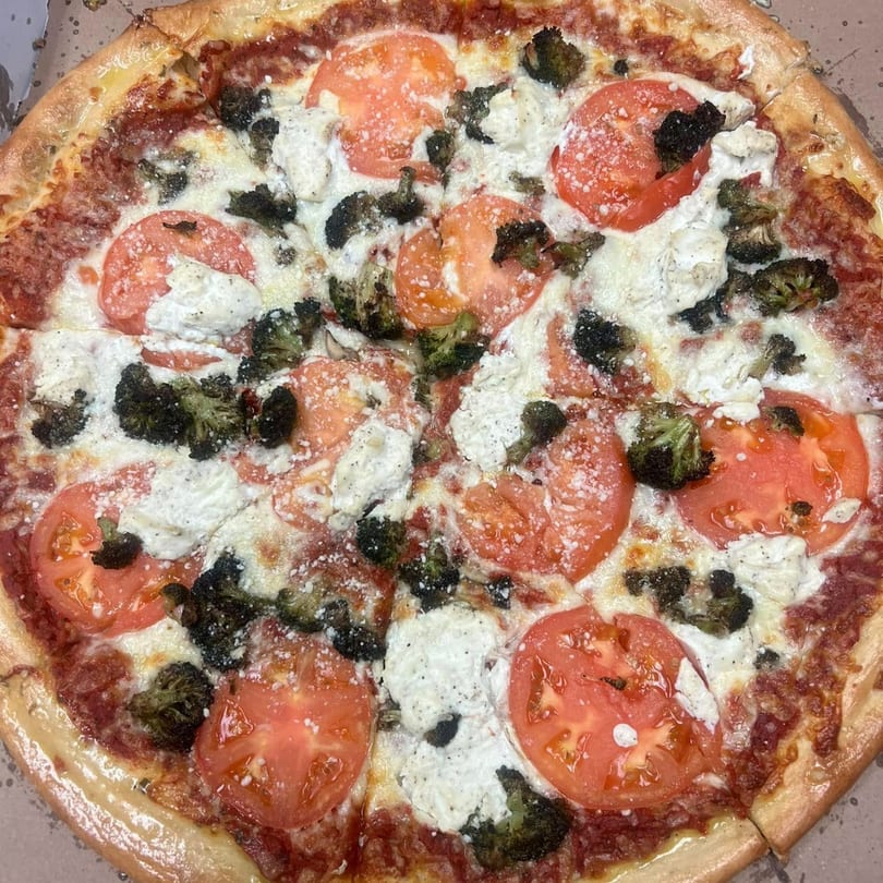 West End Kitchen & Catering pizza with tomato slices, broccoli, and ricotta cheese.