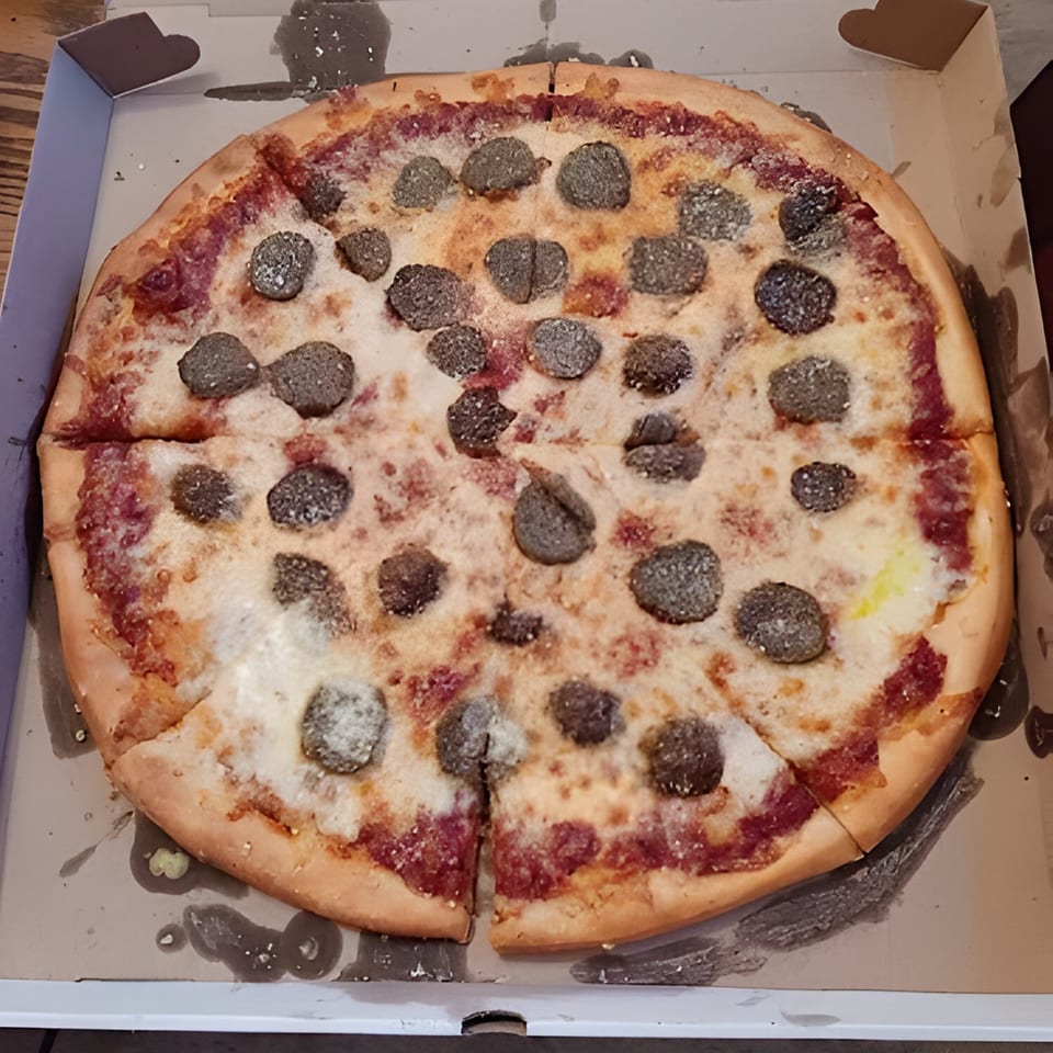 A whole West End Kitchen & Catering pizza with sausage and cheese in a delivery box.