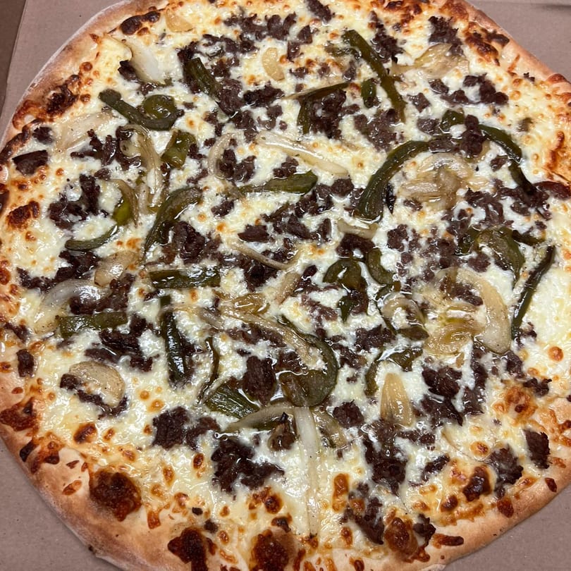 West End Kitchen & Catering's pizza with white cheese, ground meat, green peppers, and onions.